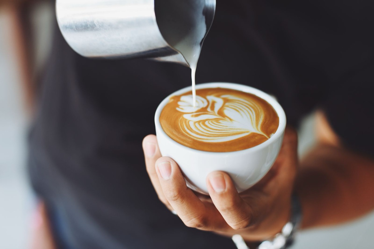 Barista nalévá latte art do šálku — web pro kavárnu krok za krokem